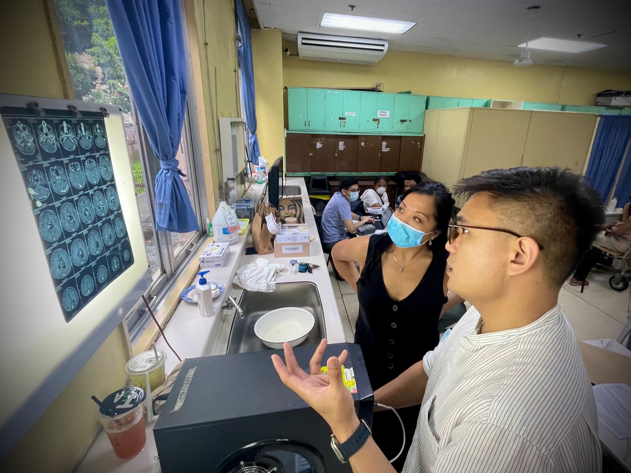 Dr. Patricia Quebada-Clerkin (Peds Section faculty) and neurosurgery resident Dr. EJ Cayanong (PGH) discussing patients in neurosurgery resident clinic at Philippines General Hospital in Manila, 2023